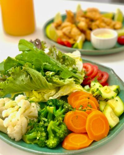 two plates of food with vegetables on a table at Hotel Casa Paradiso Guarujá in Guarujá