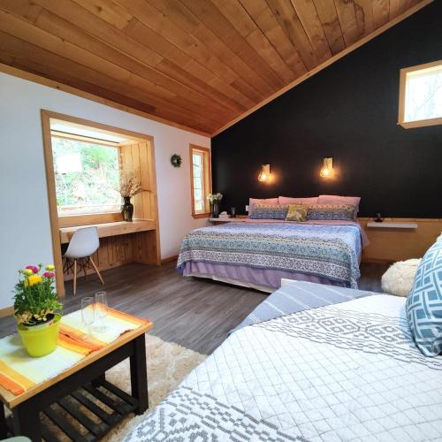 a large bedroom with two beds and a table at Hummingbird B&B in Gabriola