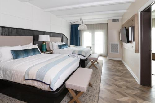 a hotel room with two beds and a tv at The Inn at Harbor Shores in Saint Joseph