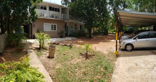 a car parked in a yard in front of a house at Coral House SAI in El Cove