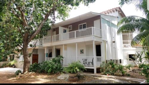 a large white house with a tree in front of it at Coral House SAI in El Cove