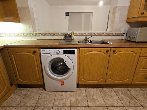 a kitchen with a washing machine and a sink at Spacious single room in Nottingham