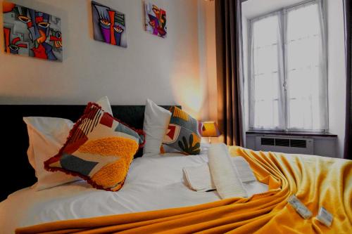 un lit avec des draps blancs et des oreillers dans une chambre dans l'établissement La Maison Bleue, à Oupia