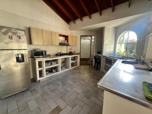 a kitchen with a stainless steel refrigerator and a table at Coral House SAI in El Cove