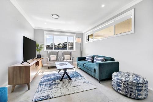 a living room with a couch and a tv at Devan House - An Entertainers' Retreat Close to Town in Mudgee