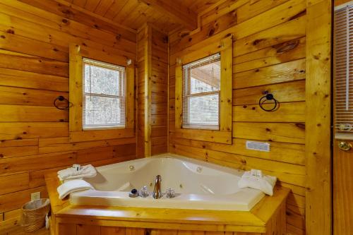 baño con bañera en una cabaña de madera en Sugar Bear Cabin, en Sevierville