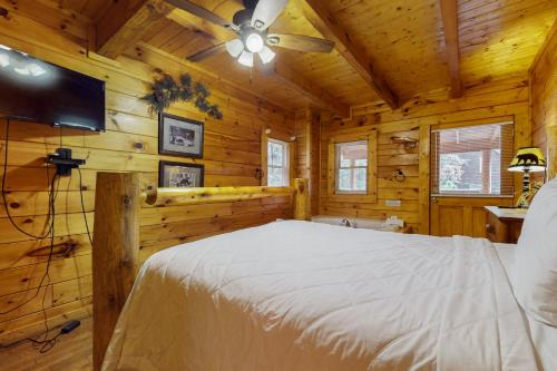 Un dormitorio con una cama en una cabaña de madera. en Sugar Bear Cabin, en Sevierville