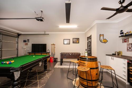 a living room with a pool table and some chairs at Devan House - An Entertainers' Retreat Close to Town in Mudgee