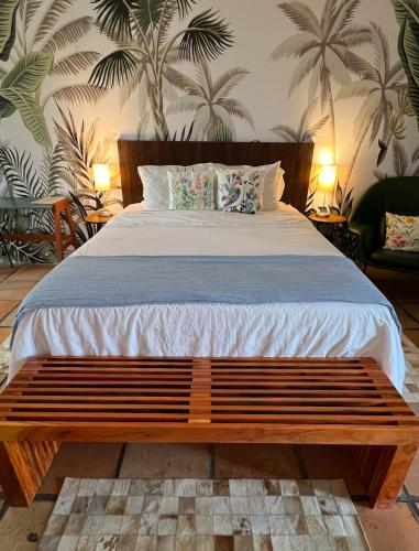 a bed with a wooden bench in a bedroom at Hotel Casa Paradiso Guarujá in Guarujá