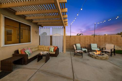 a patio with a couch and chairs and a fire pit at Casa Desert Muse with Heated Pool Spa Firepit Mini Golf and Games in Indio