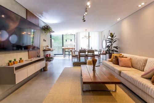 a living room with a couch and a table at Star Green 211 - Triplex com linda vista e ótima localização in Campos do Jordão