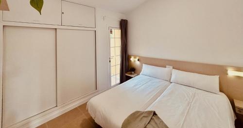 une chambre avec un lit blanc et une fenêtre dans l'établissement Click&Guest - Golden Sands in Maspalomas, à San Fernando