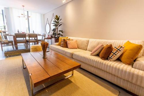 a living room with a couch and a coffee table at Star Green 211 - Triplex com linda vista e ótima localização in Campos do Jordão