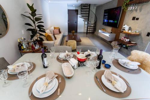 a table with plates and wine glasses on it at Star Green 211 - Triplex com linda vista e ótima localização in Campos do Jordão