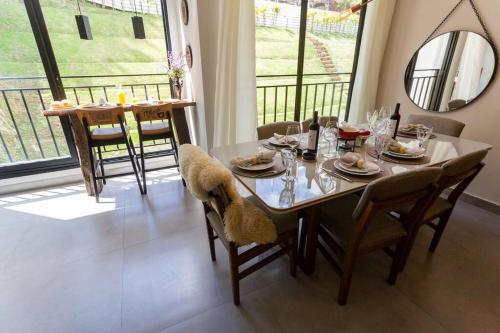 a dining room with a table and chairs and a balcony at Star Green 211 - Triplex com linda vista e ótima localização in Campos do Jordão