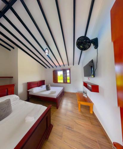 a large room with two beds and a table at Hotel Campestre Villa Salome in Quimbaya