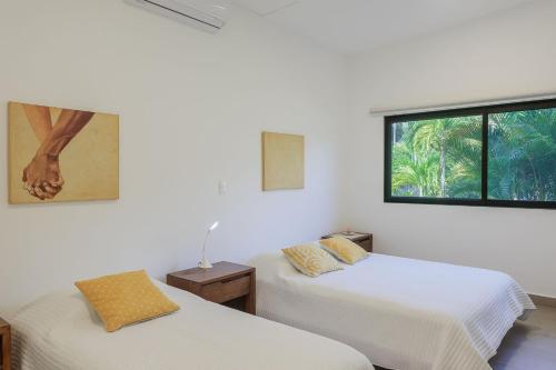 due letti in una stanza con finestra di Ayanna Beach Front Heaven a La Libertad