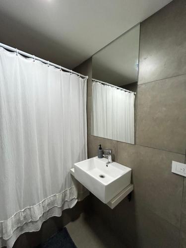 ein Badezimmer mit einem weißen Waschbecken und einem Spiegel in der Unterkunft Departamento Flores in Buenos Aires