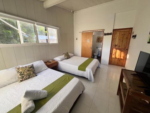 a room with two beds and a television in it at Coral House SAI in El Cove