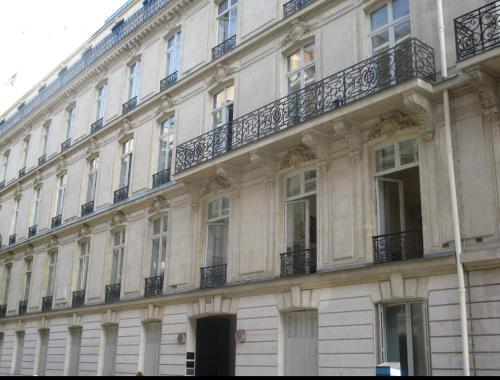 - un grand bâtiment blanc avec des fenêtres et des balcons dans l'établissement APT 10P 160m2 WITH TERACe, à Paris