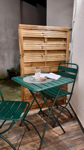 une table et des chaises vertes à côté d'un meuble en bois dans l'établissement Chic appartement en plein cœur de Paris, à Paris