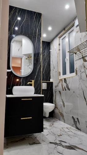 une salle de bain avec un lavabo et un miroir dans l'établissement Chic appartement en plein cœur de Paris, à Paris