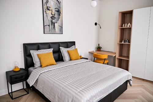 a bedroom with a large bed with yellow pillows at Urban Chic Apartment in the Heart of Mechelen in Mechelen