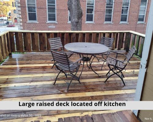 a wooden deck with a table and chairs on it at The John Sydney House in Hannibal