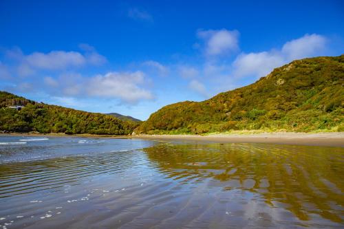 a sandy beach with mountains in the background at Cozzy Cabin at "Explore-Cafe & Lodge" Located in Duhatao, Chiloe Island, Patagonia, Chile in Ancud