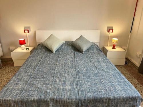 a bedroom with a bed with two tables and two lamps at Alloggio turistico in Pisa