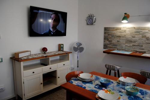a dining room with a table and a tv on the wall at Alloggio turistico in Pisa