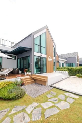 a modern house with glass windows and a patio at The Family at Khaoyai in Wangkata