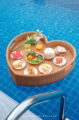 a tray of food on a table in a swimming pool at The Family at Khaoyai in Wangkata