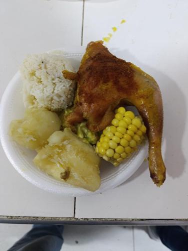 a plate of food with chicken and corn and rice at Quinta de san pedro in Villavicencio