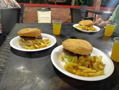 a table with three plates of food and fries at Quinta de san pedro in Villavicencio