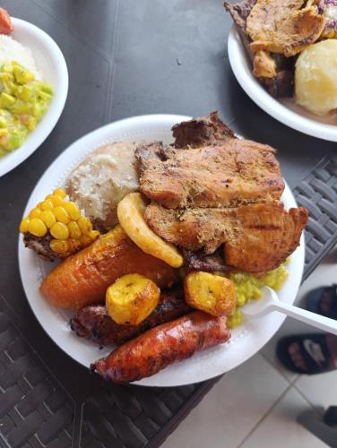 a plate of food with meat and vegetables on a table at Quinta de san pedro in Villavicencio