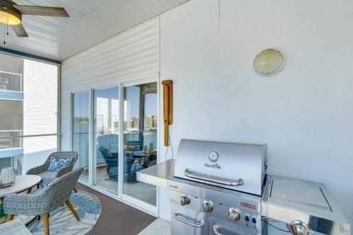 a kitchen with a stove and a table with a laptop at Sunshine Shack Lake Ozark Condo Pool, Lake View in Lake Ozark