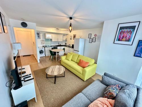un salon avec un canapé et une cuisine dans l'établissement Charmant 2 Pièces avec Parking Près de Paris by Immo Kit BNB, à La Courneuve