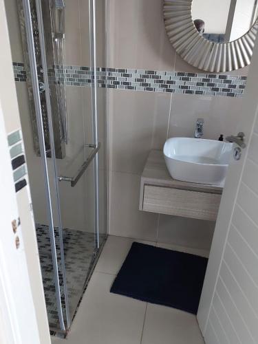 a bathroom with a shower and a sink and a mirror at Champagne Manor in Mountain Herberg Hostel