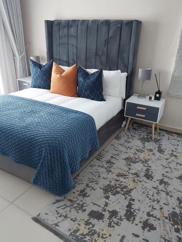 a bedroom with a large bed with a blue comforter at Champagne Manor in Mountain Herberg Hostel