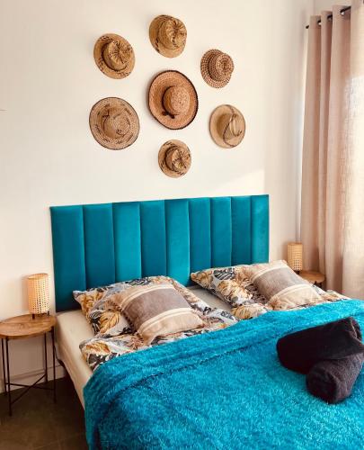 a bedroom with a blue headboard with hats on the wall at MoryńApartments ROOMS in Moryń