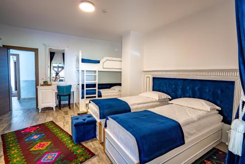 a bedroom with two beds and a blue headboard at Poarta Maramureșana Borșa Complex in Statiunea Borsa