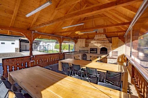 a dining room with wooden tables and chairs at Poarta Maramureșana Borșa Complex in Statiunea Borsa