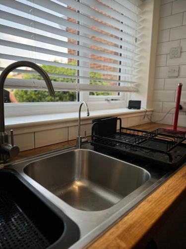 a stainless steel sink in a kitchen with a window at Milan Casa in Winnersh