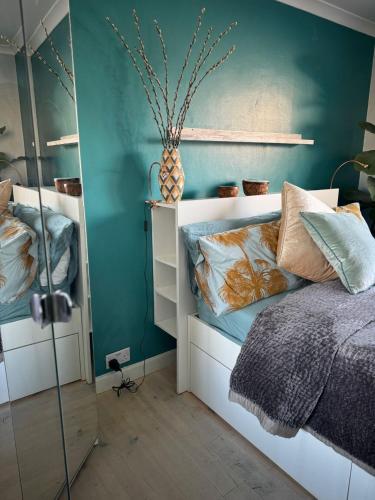 a bedroom with a bed and a green wall at Milan Casa in Winnersh