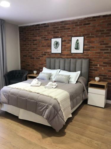 a bedroom with a large bed and a brick wall at Puente de la Mujer in Buenos Aires