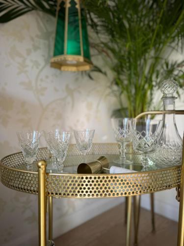 a table with glasses on it in a room at Milan Casa in Winnersh