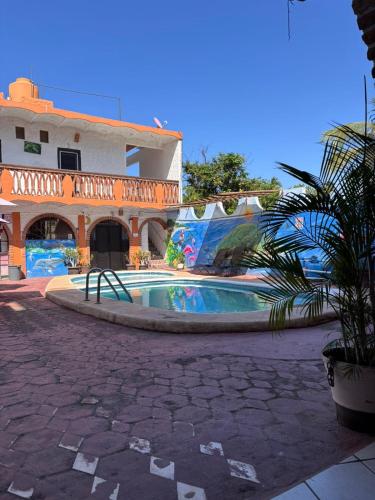 a swimming pool in front of a building at Bungalows Flamingos in Rincon de Guayabitos