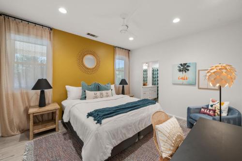 a bedroom with a large bed and a chair at Casa Desert Muse with Heated Pool Spa Firepit Mini Golf and Games in Indio