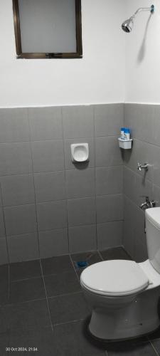 a bathroom with a toilet and a mirror at Nana Homestay in Parit Buntar